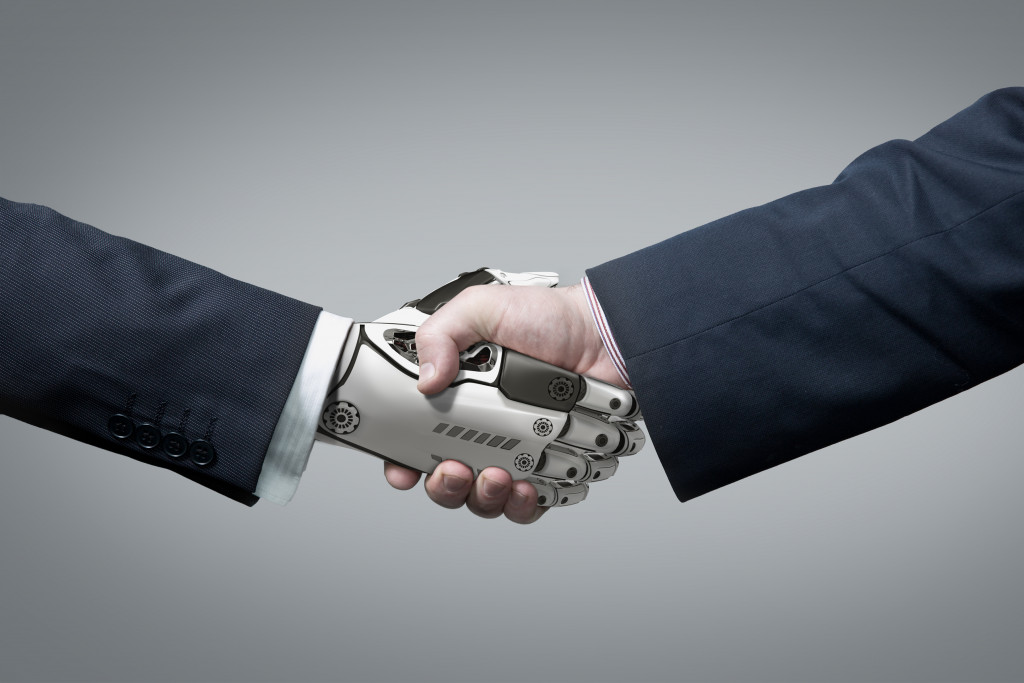 human hand and robot shaking hands