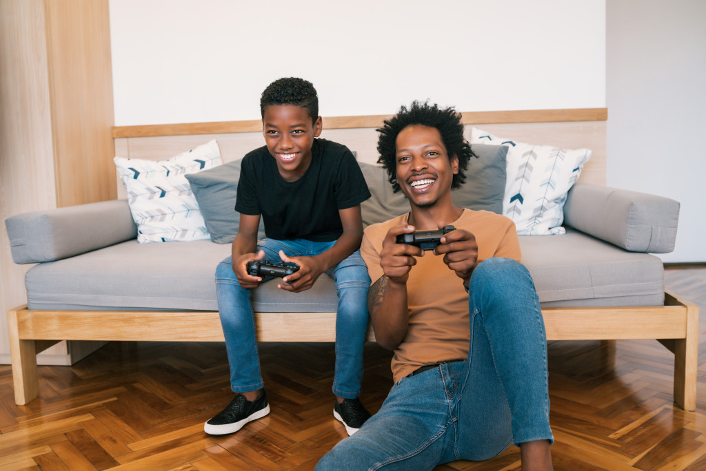 father and son playing a console video game on their living room