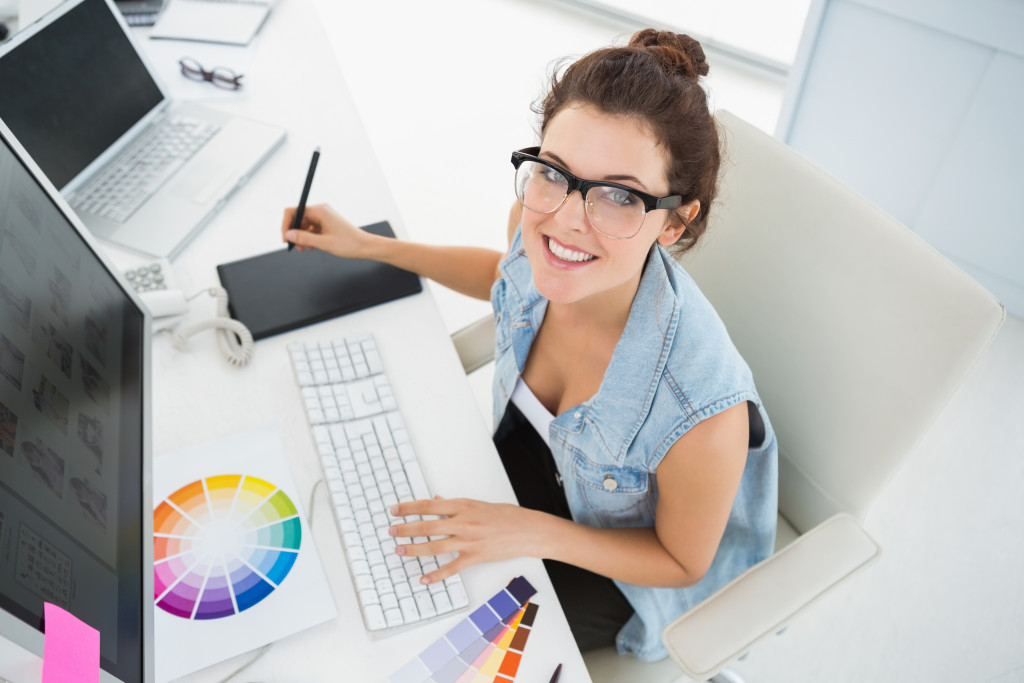 an artist at work with color palettes at the desk