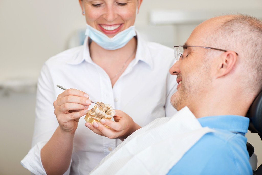 a dentist showing a dental implant to the patient