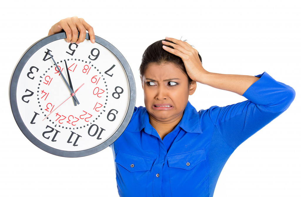 A woman holding a clock to portray she is running out of time