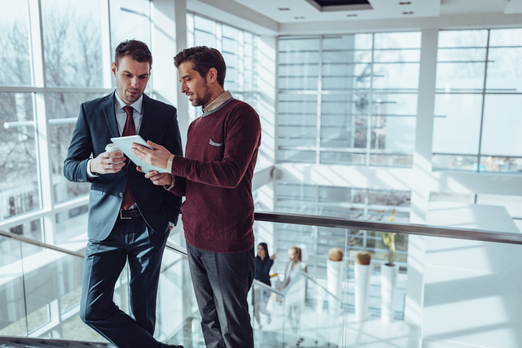 Two business partners discussing project in office lobby 