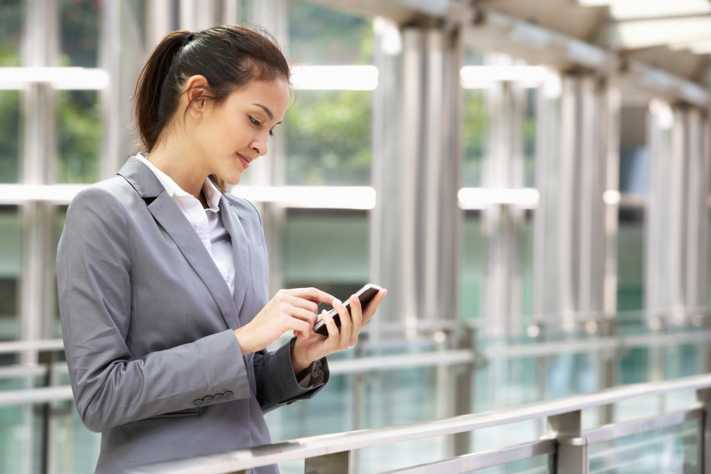 a businesswoman using a phone while outside 