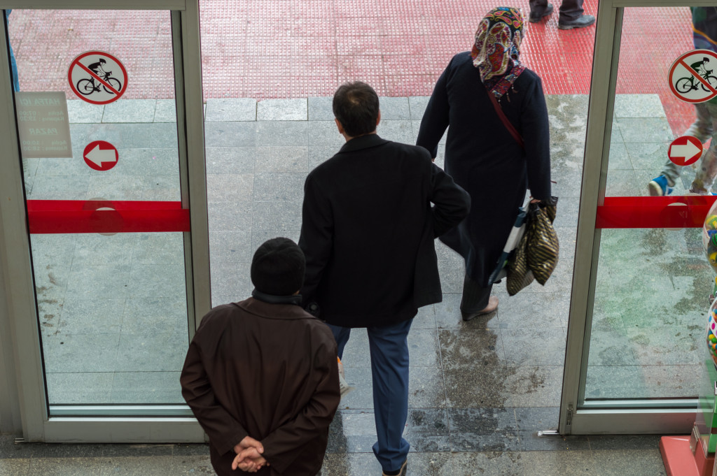 Customers passing through security doors in a retail store.