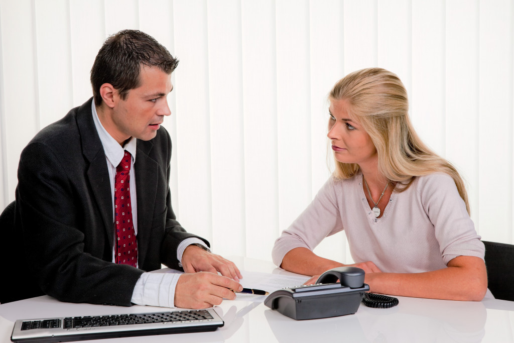 Young woman signing the employment contract in her new office 