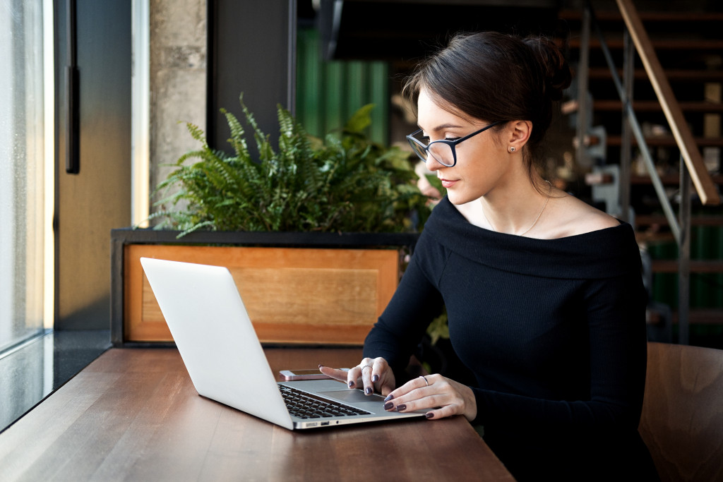 Young woman managing her online business using a laptop.