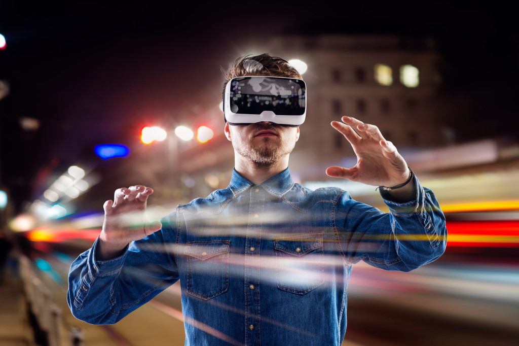male wearing VR goggles in a city scape at night
