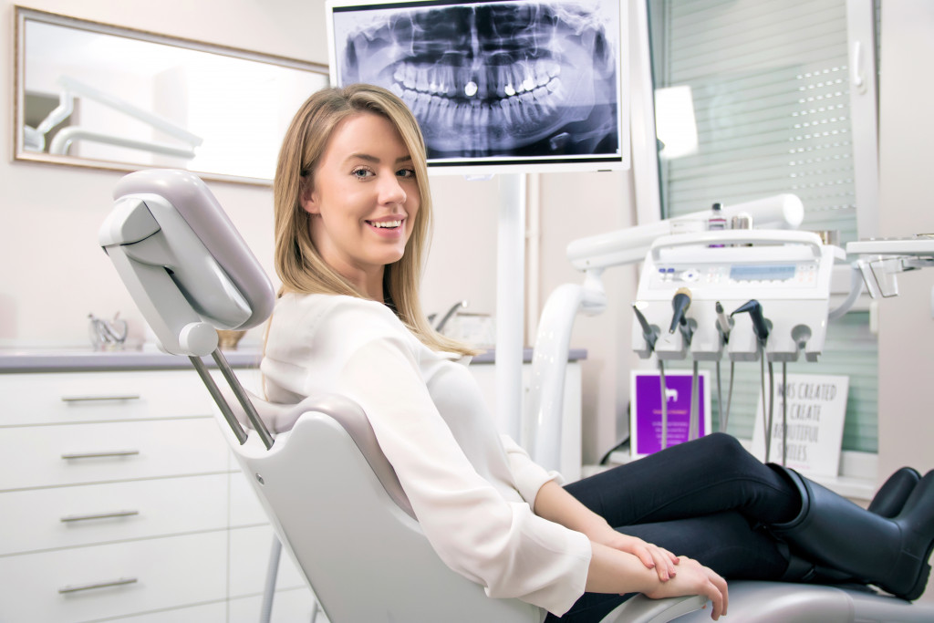 a patient sitting on a dentist's chair while getting an oral scan
