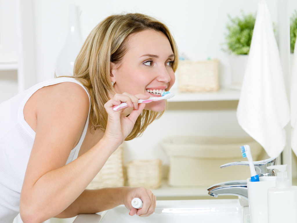 woman in the bathroom brushing her teeth