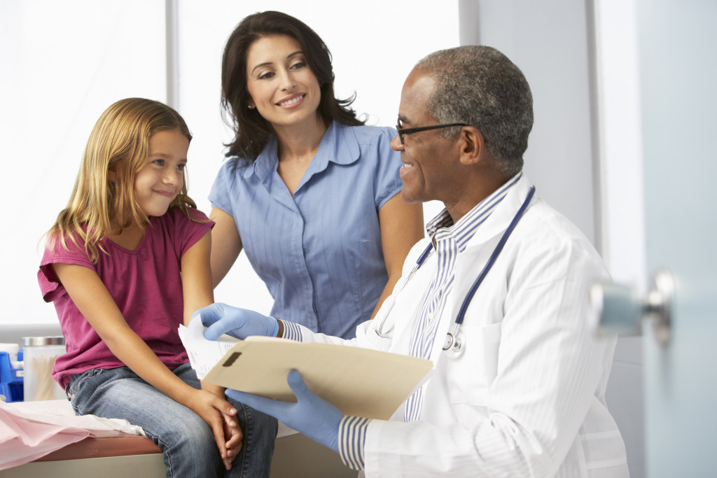 patient being talked to by parent and doctor